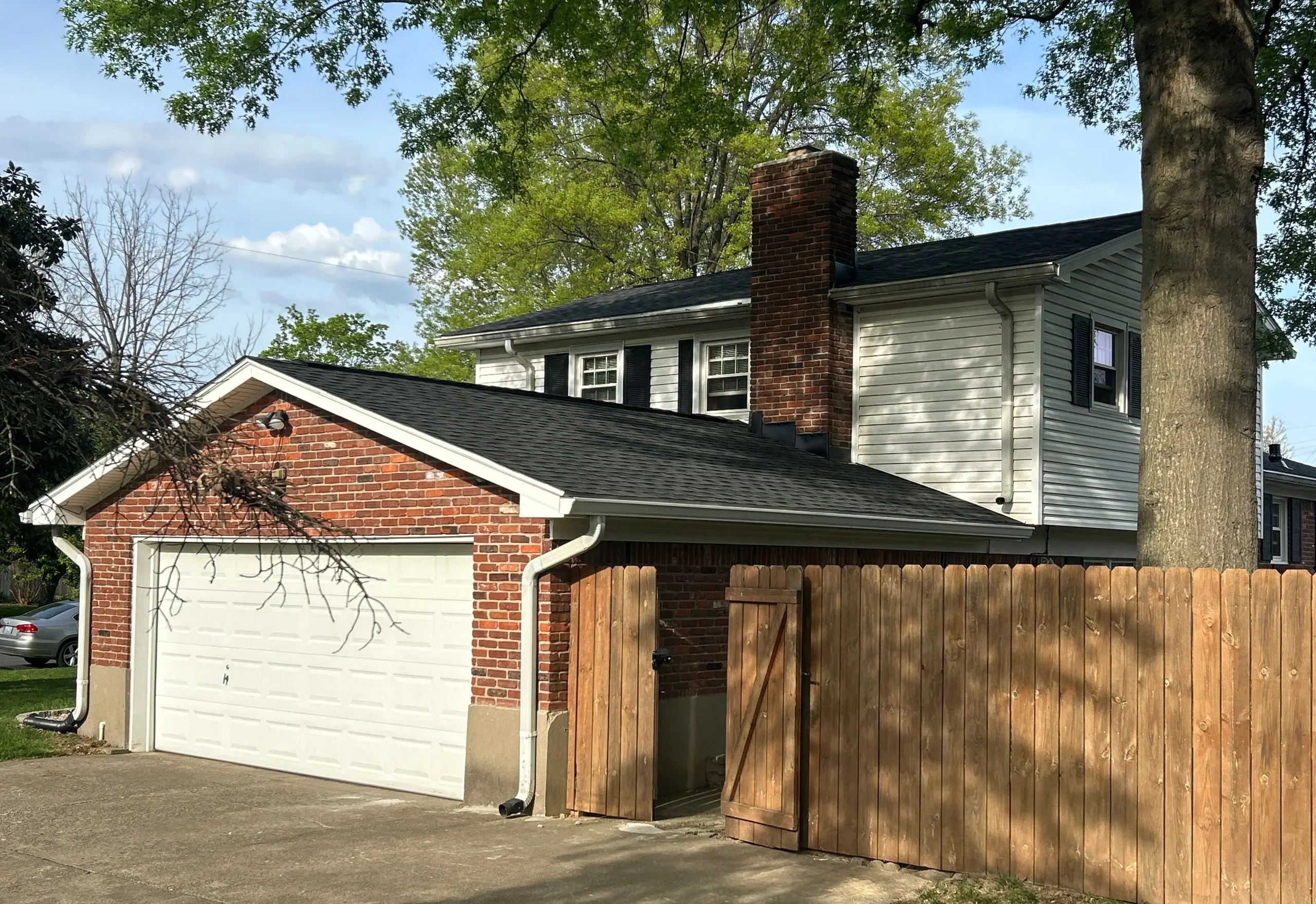 Brick and siding home in Louisville, KY with a new roof installed by AIC Roofing & Construction.