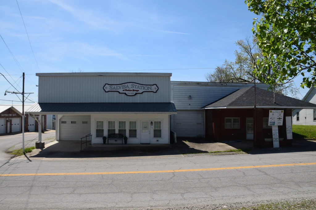 Street view of Salvisa Station and neighboring buildings in downtown Salvisa, KY on a sunny day.