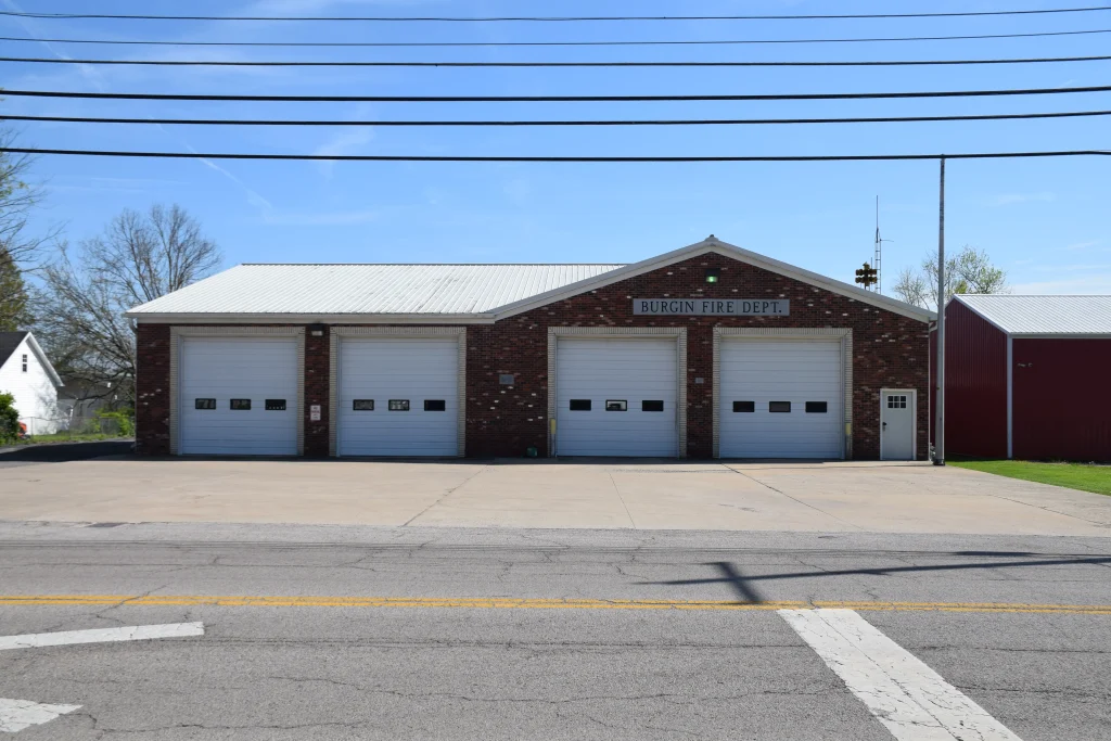 Exterior view of the Burgin Fire Department in Burgin, KY, featuring four garage bays and a brick facade.
