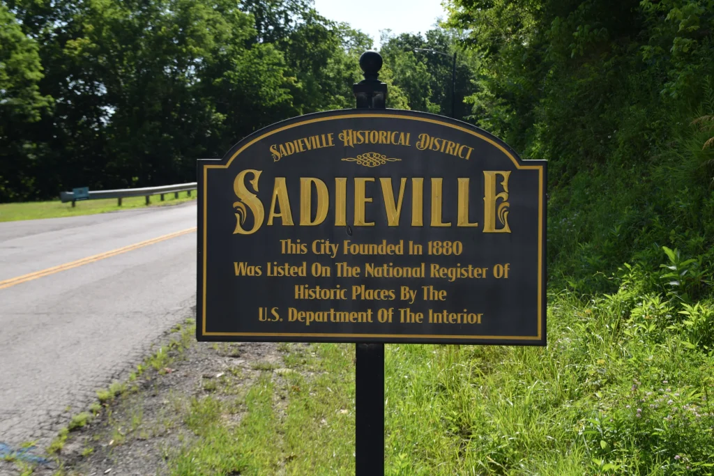 Historic district sign for Sadieville, KY stating its 1880 founding and recognition on the National Register of Historic Places.