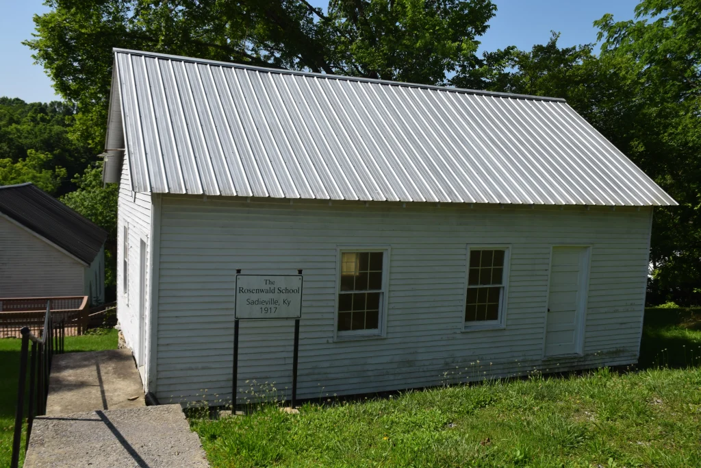 A small white wooden building with a metal roof, identified as the Rosenwald School in Sadieville, KY, established in 1917.