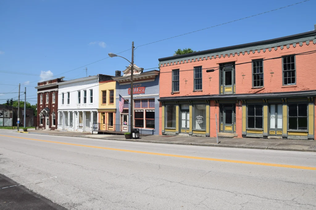 Colorful row of historic commercial buildings along Main Street in Millersburg, KY, under a clear blue sky.