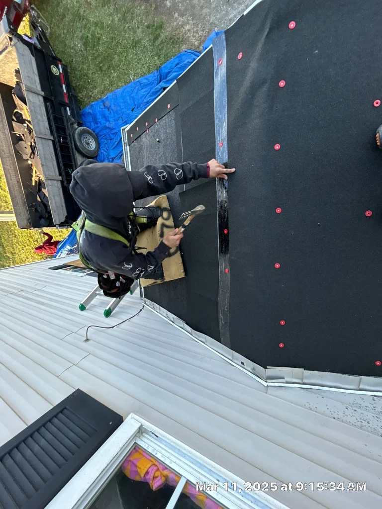 Roofer performing detailed roof repair on a home in Louisville, KY, applying underlayment and fasteners.