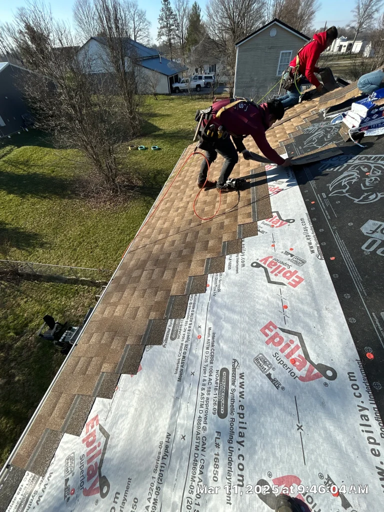 Roofers installing new shingles during a roof repair in Bagdad, KY, with AIC Roofing.