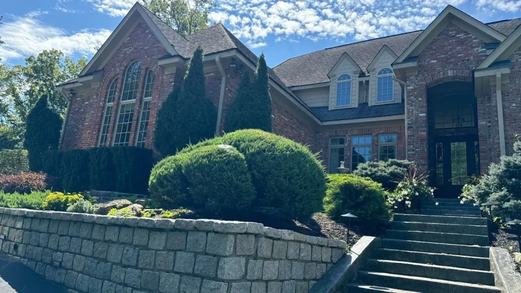 Large brick home in Fisherville, KY with a newly replaced roof by AIC Roofing, featuring architectural shingles and manicured landscaping.