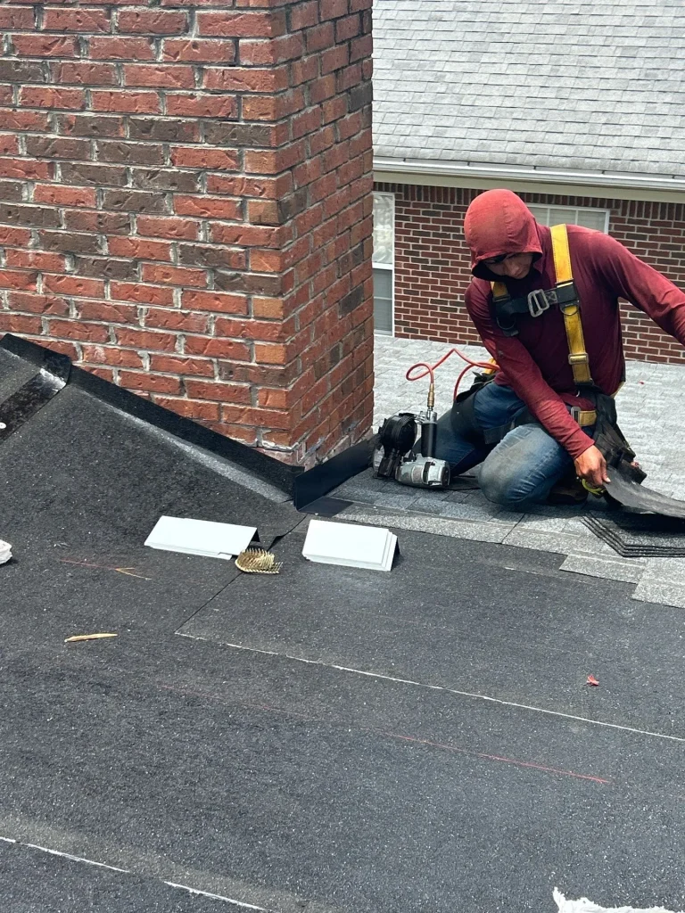 AIC Roofing crew member performing a roof repair on a home in Westport, KY using safety gear and professional tools.
