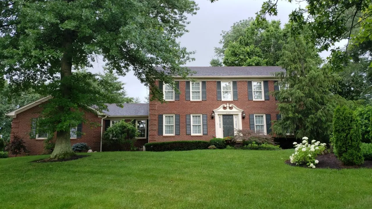 Roof replacement on a two-story brick home in Lexington, KY by AIC Roofing & Construction.