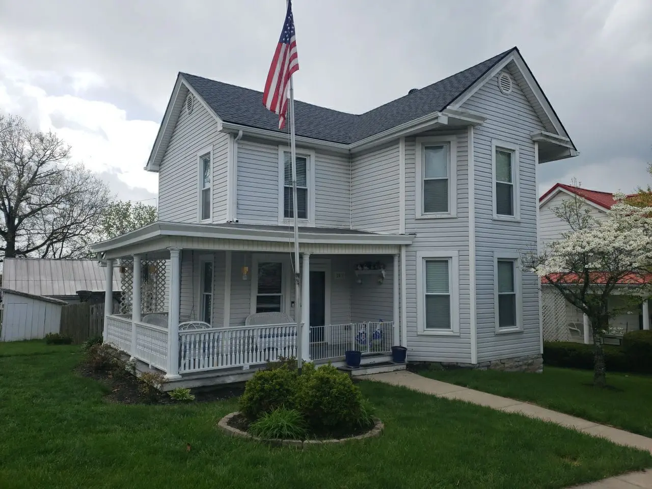 Front view of a two-story home in Millersburg, KY, with a new roof installed by AIC Roofing & Construction.