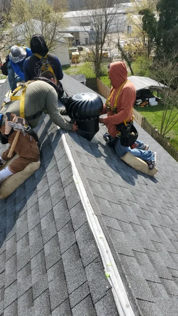 Crew members installing a roof vent during a roof repair on a home in Millersburg, KY, by AIC Roofing & Construction.