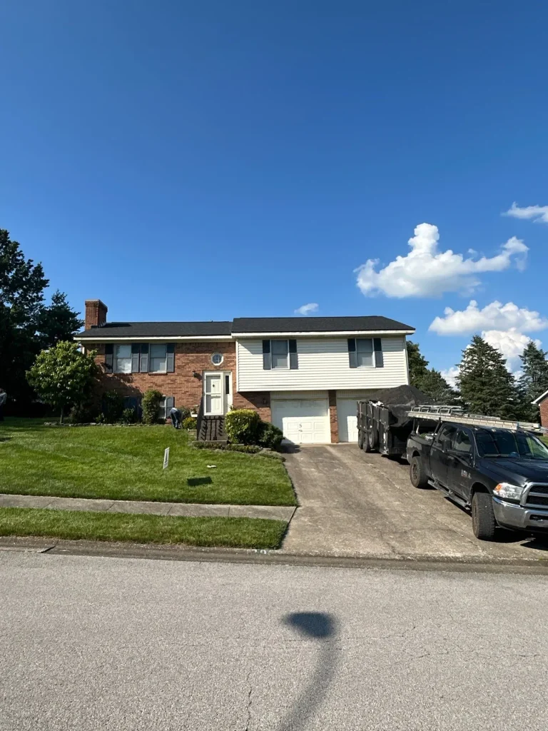 A Richmond, KY split-level home with a newly installed roof by AIC Roofing & Construction under a clear blue sky.