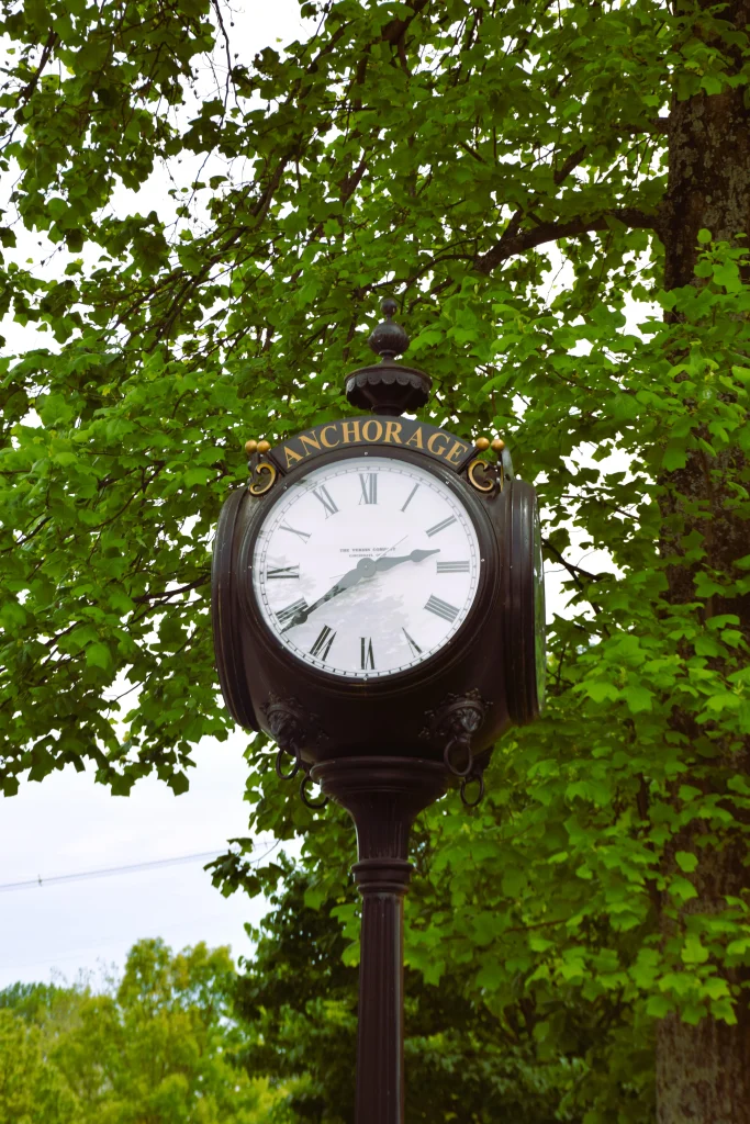 Vintage-style street clock in Anchorage, KY, surrounded by leafy trees