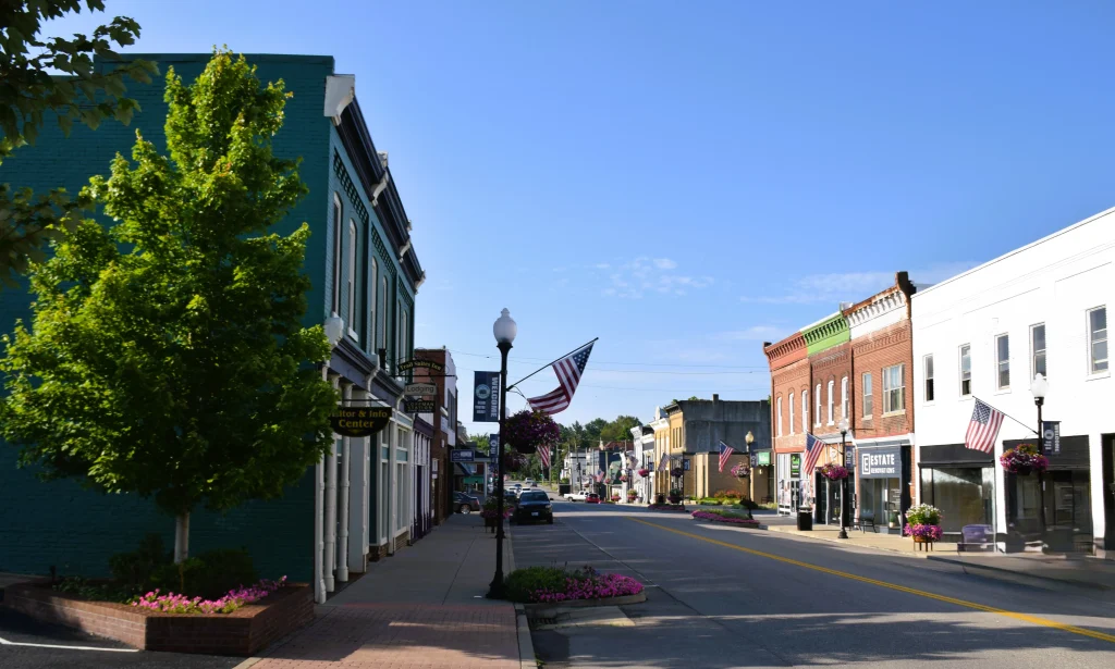 Main Street in downtown Lawrenceburg, KY with American flags and small businesses