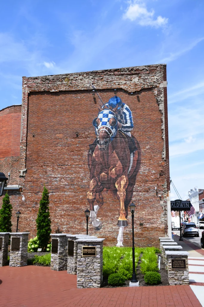 Mural of Secretariat and jockey painted on a brick building in downtown Paris.