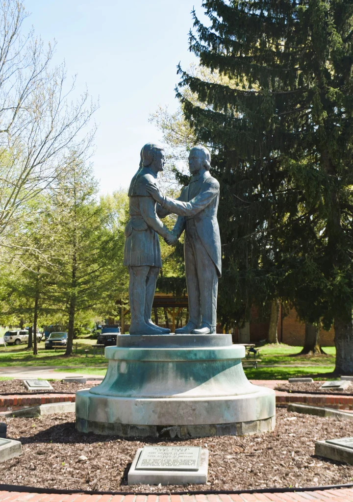 Historic bronze statue of handshake between figures in Danville KY park.