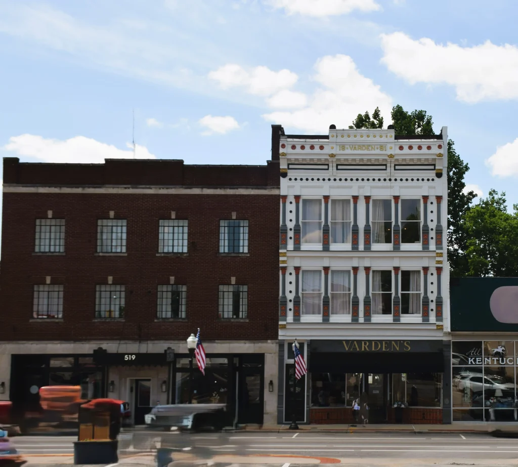 Ornate white building with black trim and storefront signage for Varden’s.