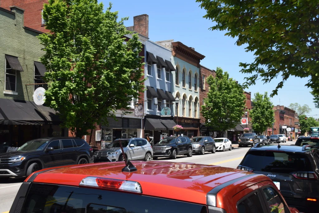 A vibrant view of downtown Bardstown, KY, featuring historic buildings and parked cars