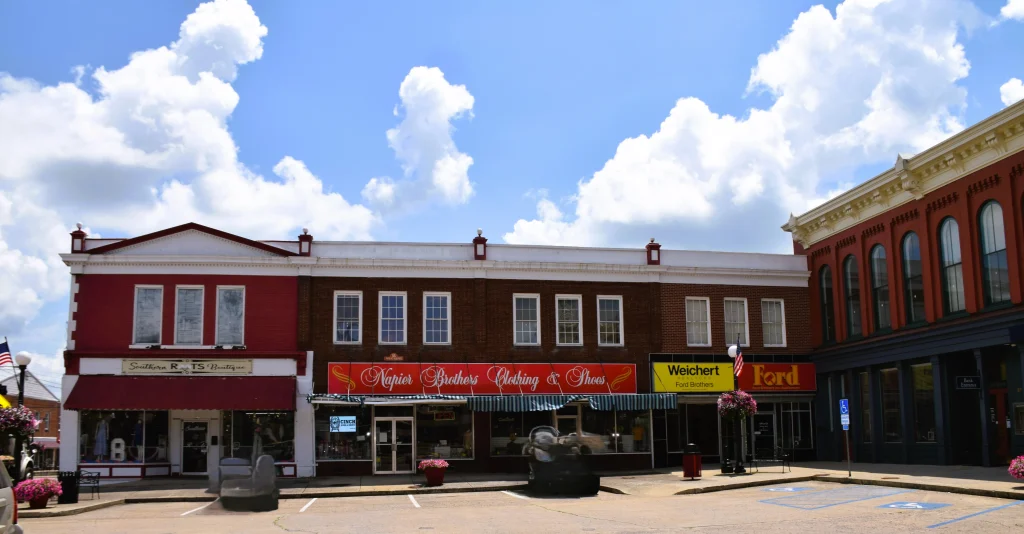 Storefronts in downtown Lancaster, Kentucky under a blue sky
