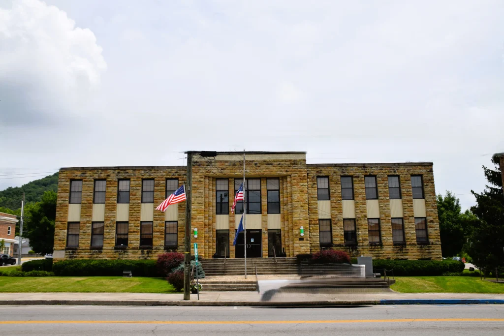 Government building with stone facade and American flags in Irvine, KY
