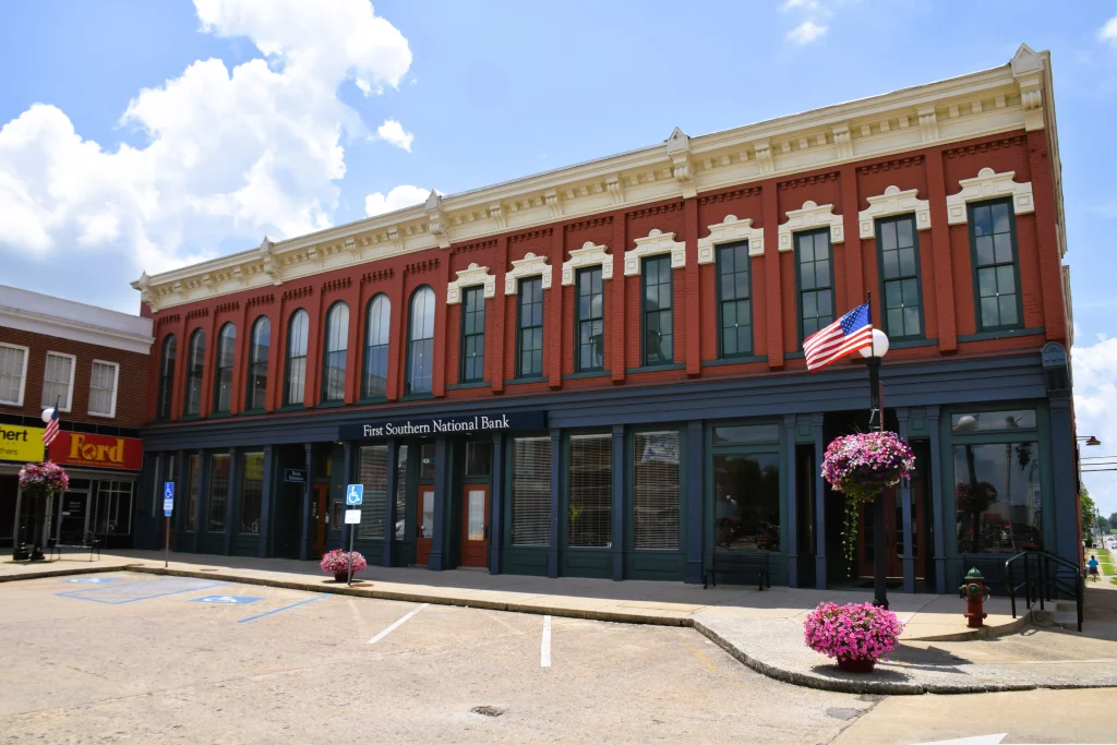Historic red brick bank building with arched windows and flag in Lancaster