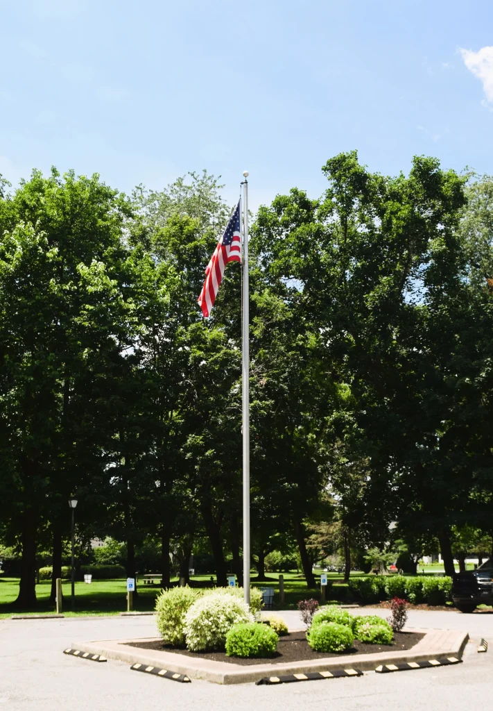 American flag flying over a landscaped area in St. Matthews, Kentucky near recent roofing projects