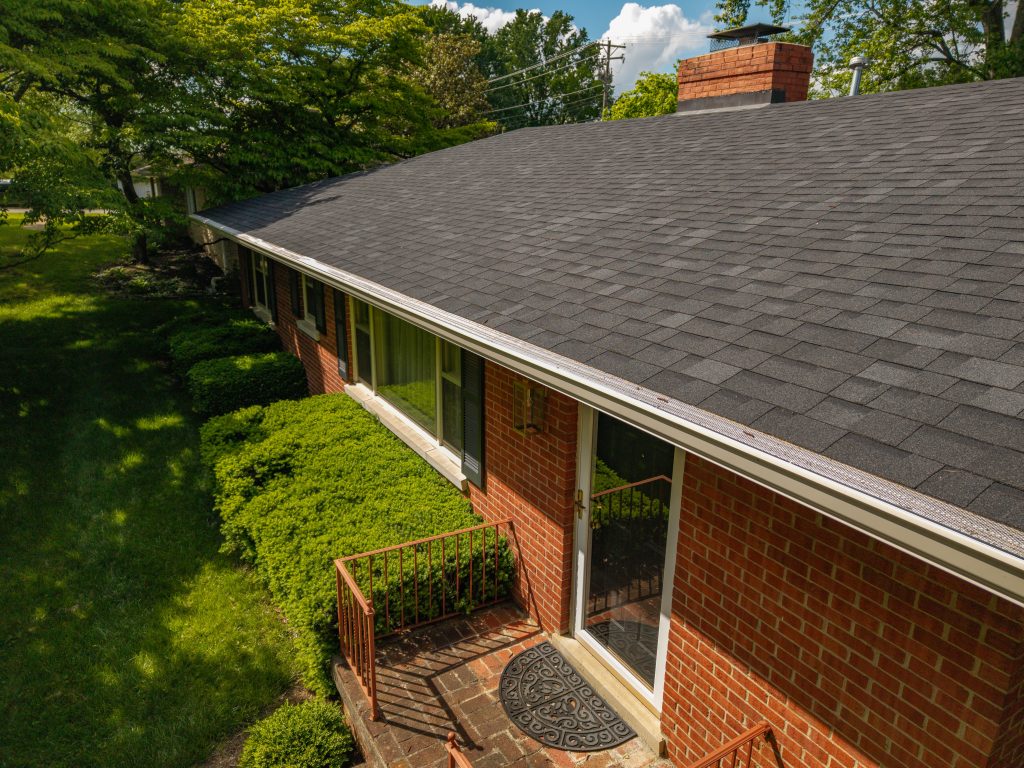 Gutter guards installed on a red brick home with asphalt shingle roofing in Kentucky.
