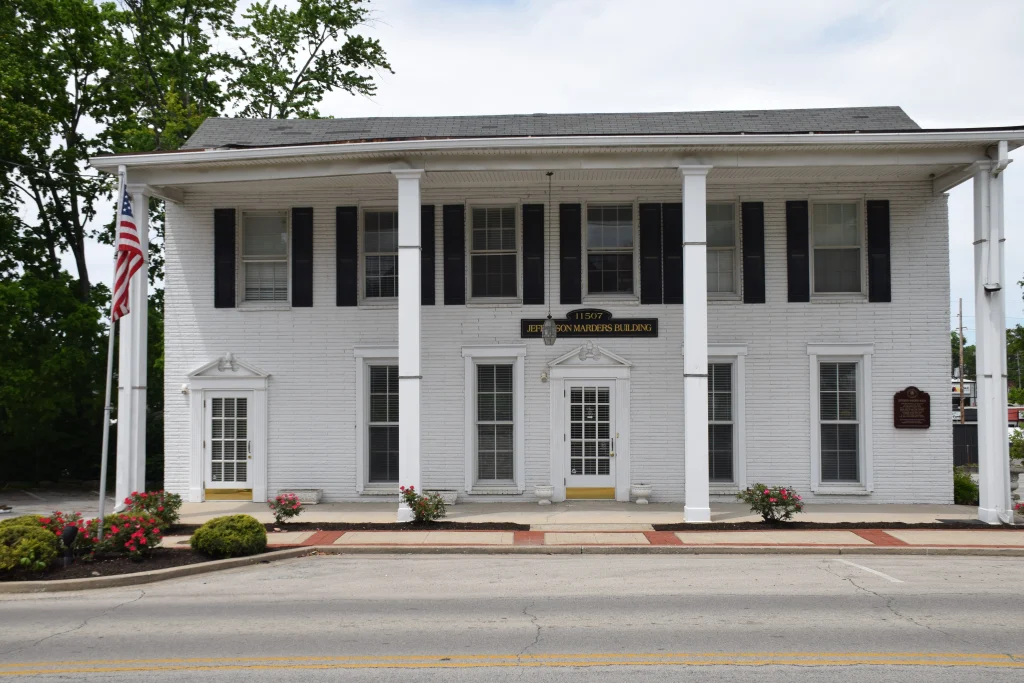 White two-story Jefferson Marders Building in Jeffersontown, Kentucky with columns and American flag