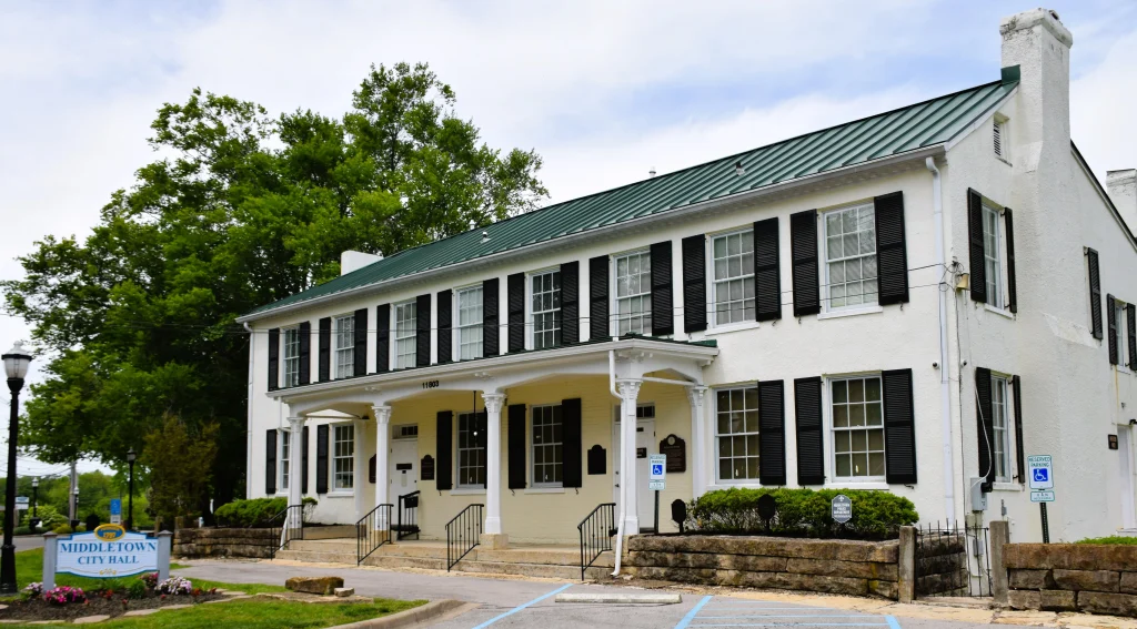 Historic white building with green metal roof and black shutters in Middletown, Kentucky