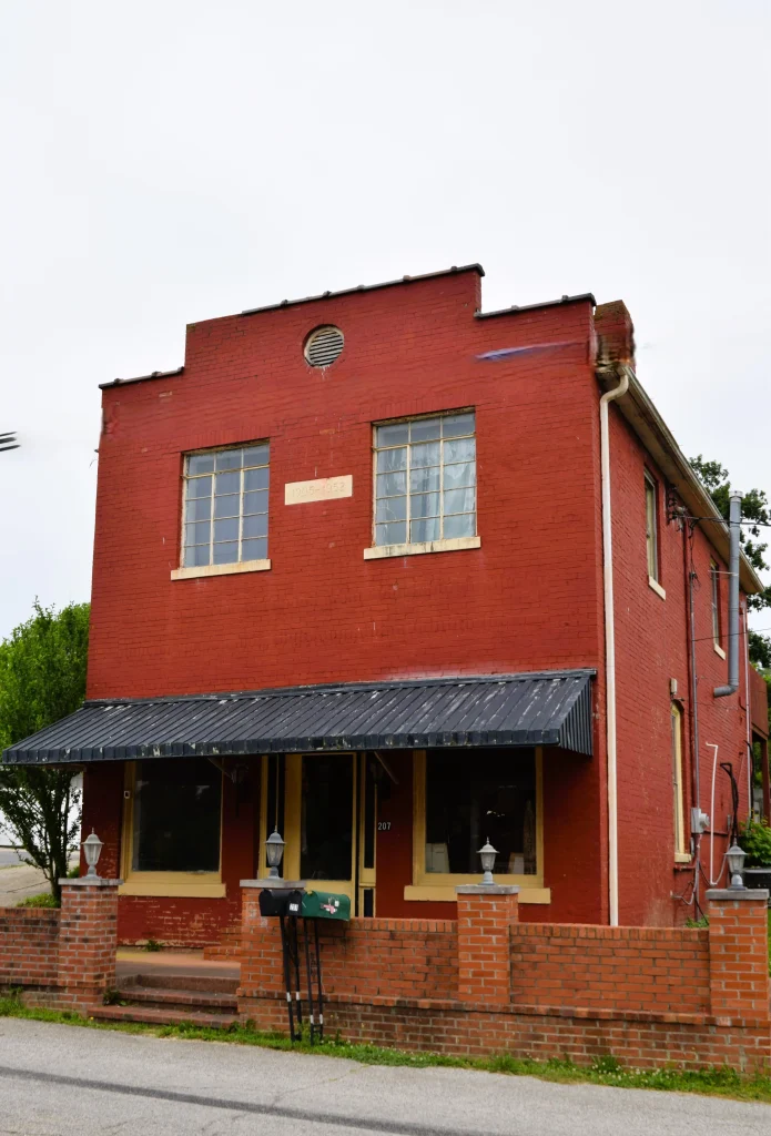 Two-story red brick building in Waco, KY dated 1905–1952.