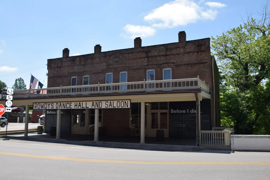 Brick building with sign reading Rowdy’s Dance Hall and “Before I Die” interactive chalkboard