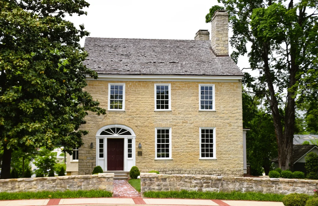 Two-story stone home with a wood shake roof in Middletown, Kentucky