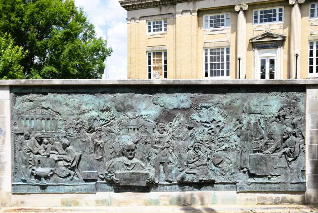 A large bronze mural showing historical scenes in front of the Park View Building in Jeffersonville