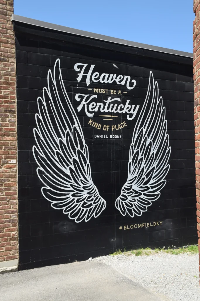 Black mural in Bloomfield KY that reads “Heaven Must Be a Kentucky Kind of Place”