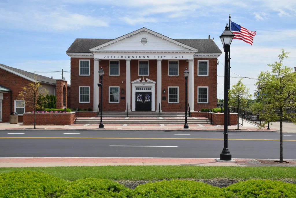 Front view of Jeffersontown City Hall with American flags and columns