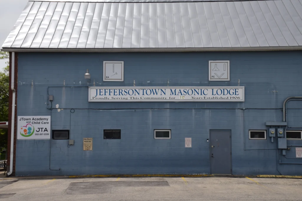 Blue building of the Jeffersontown Masonic Lodge with signage and parking area