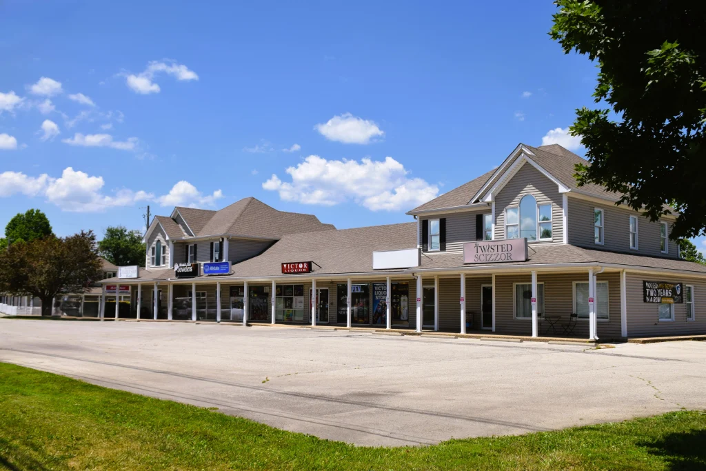 Buckner KY strip mall with various small businesses under a clear blue sky