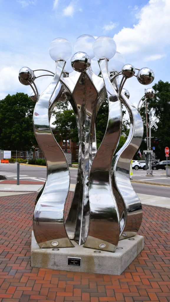 Reflective silver public art sculpture with orb-like tops in La Grange, Kentucky
