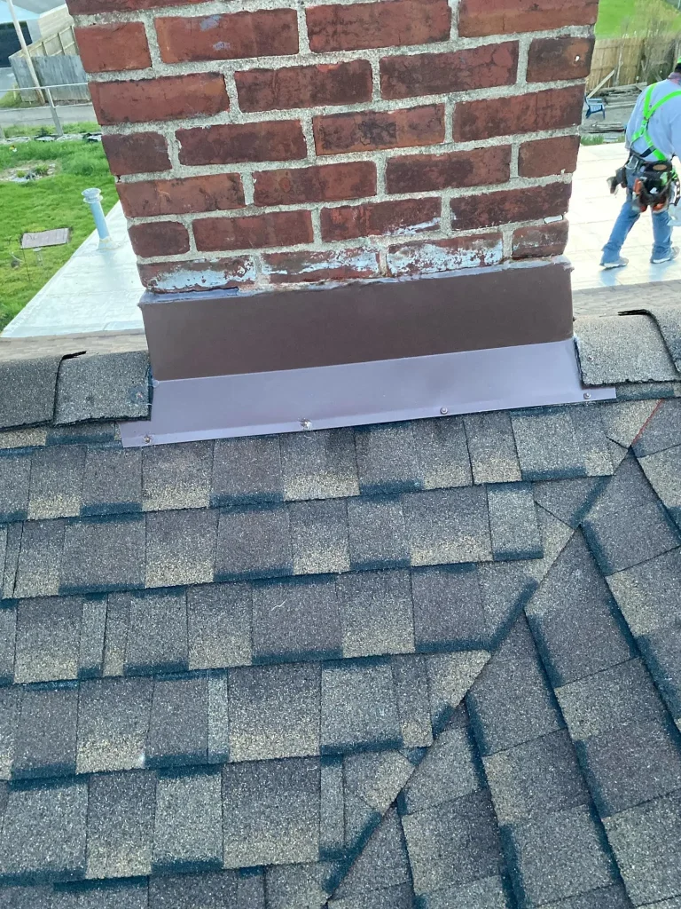 New flashing installation at the base of a brick chimney on a Louisville roof