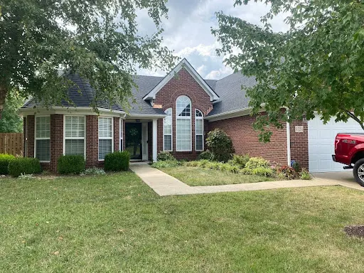 Front view of a brick home in Louisville, KY with a newly installed dark shingle roof