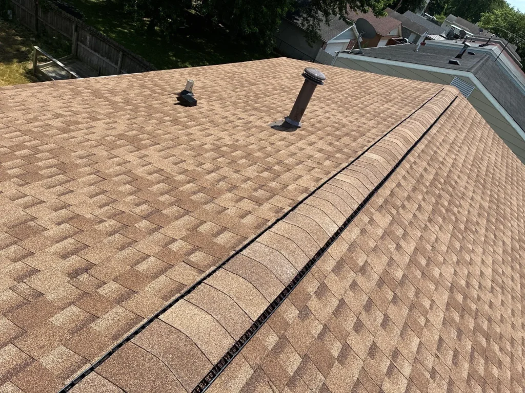 Newly installed brown shingle roof with vent penetrations and ridge vent on a Louisville home