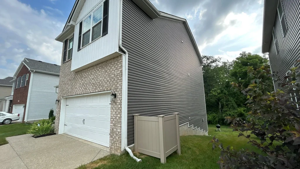 New dark vinyl siding installed on the side of a two-story home in Louisville, KY.
