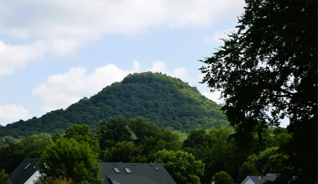 Green mountain view with visible home rooftops in Bighill, Kentucky.