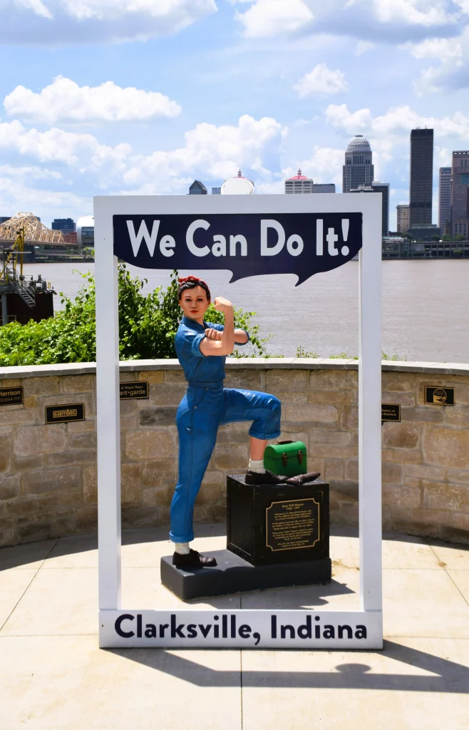 Rosie the Riveter statue display in Clarksville, Indiana, with the Louisville skyline behind