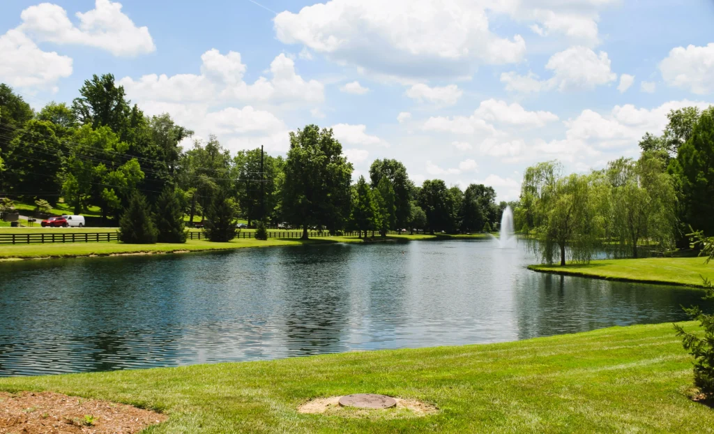 Calm lake with fountain and surrounding trees and homes in Prospect, Kentucky
