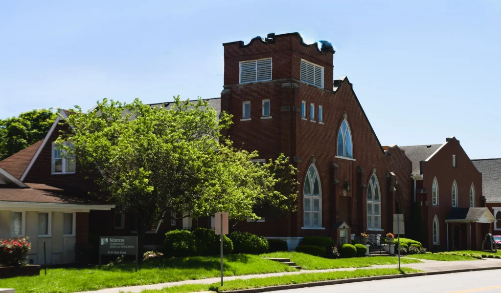 Brick church in Taylorsville with steep roof and gothic windows, an example of expert roofing structure