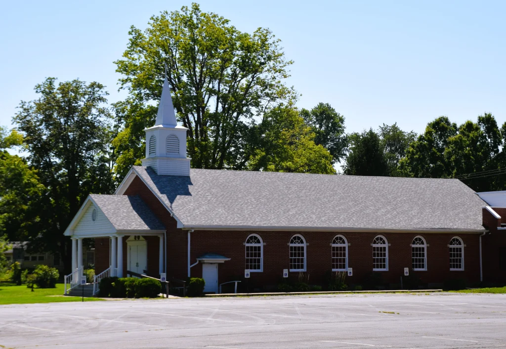 Red brick church with white steeple and arched windows in Fisherville, Kentucky