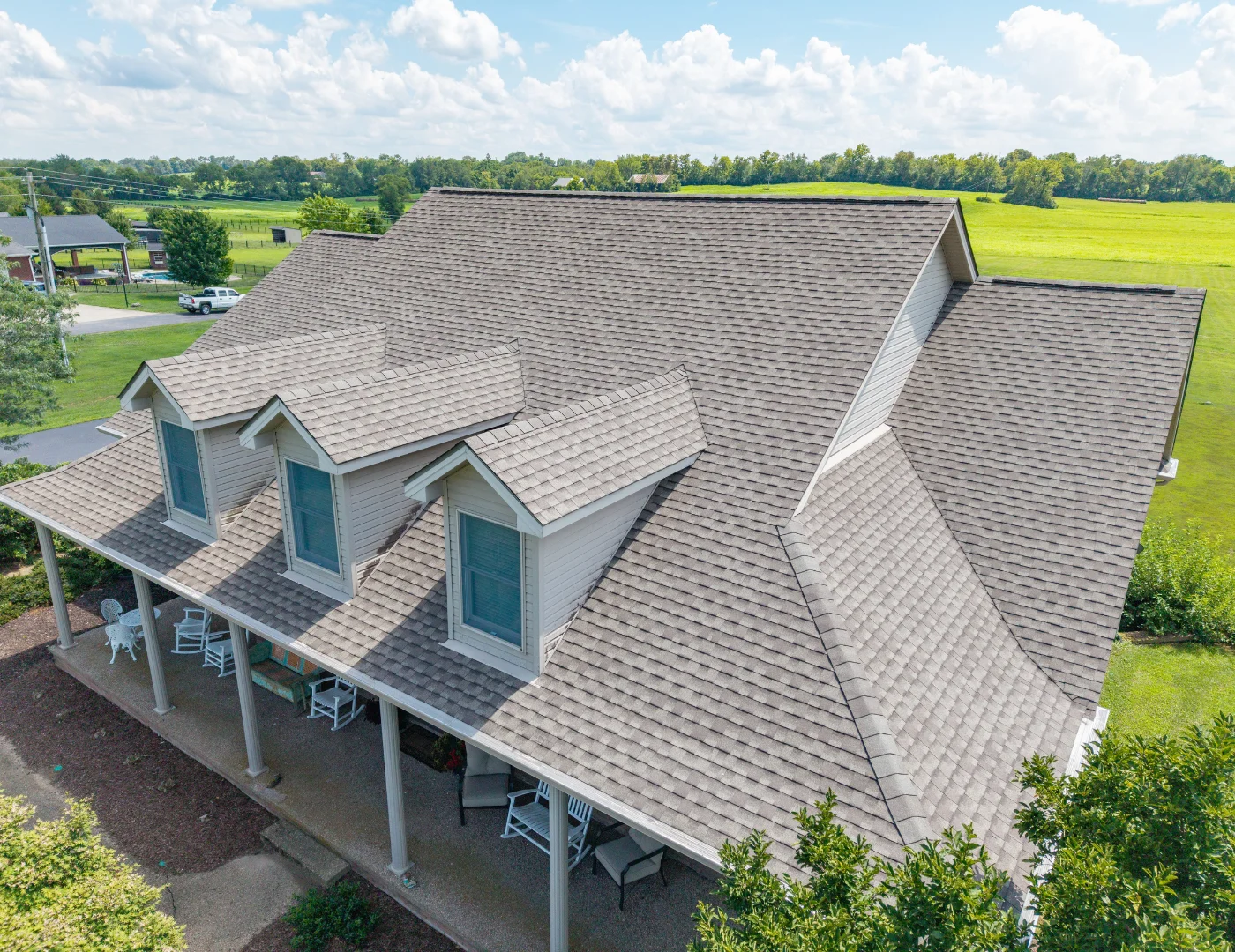 Aerial view of a brick home featuring a new GAF UHDZ shingle roof installed by a professional roofing contractor.