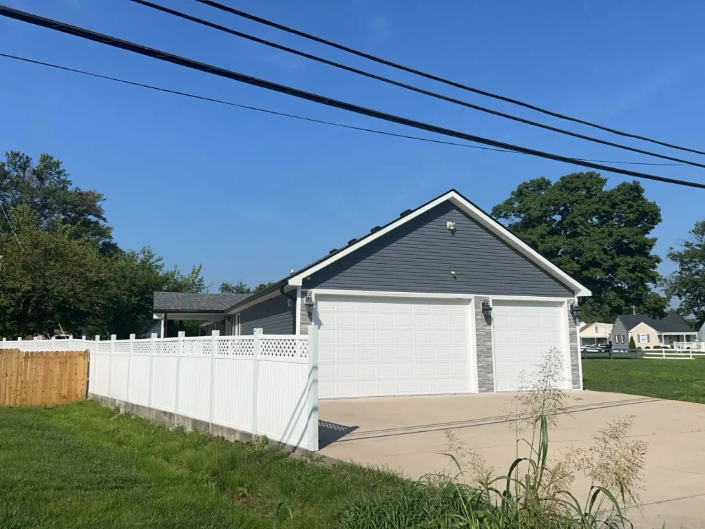 Louisville, KY home with new gray lap siding and white trim on a gable-front, double garage installed by AIC Roofing & Construction.