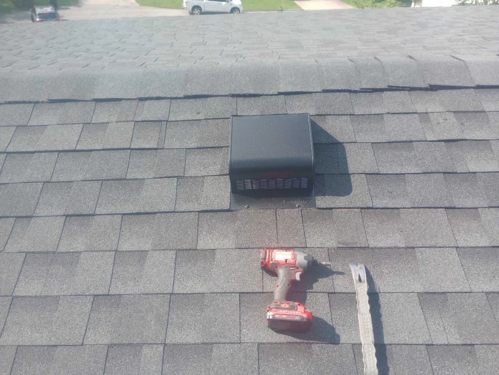 Roof Vent Installation on Louisville Home New black roof box vent installed on gray asphalt shingles near the ridge, with a drill and pry bar beside it on a Louisville home.