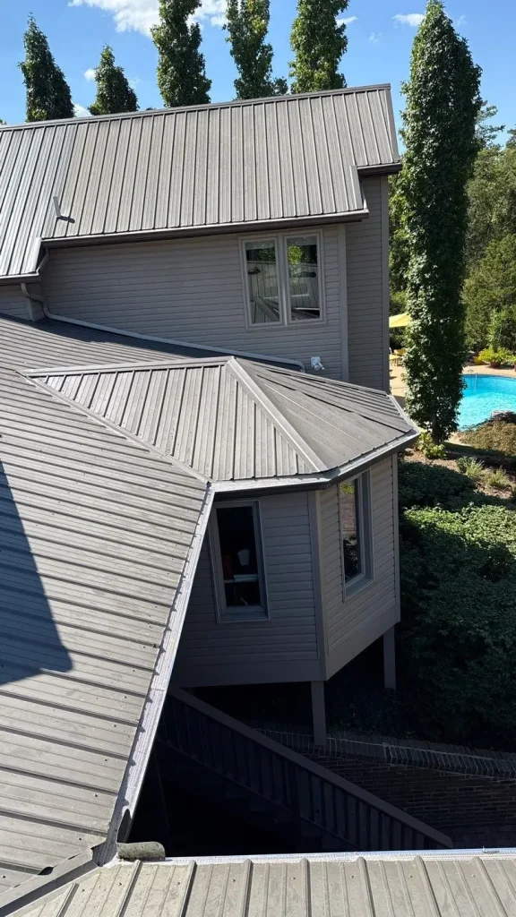 Gutter guards installed on a Louisville home with a gray metal roof, preventing clogs and protecting the gutter system.
