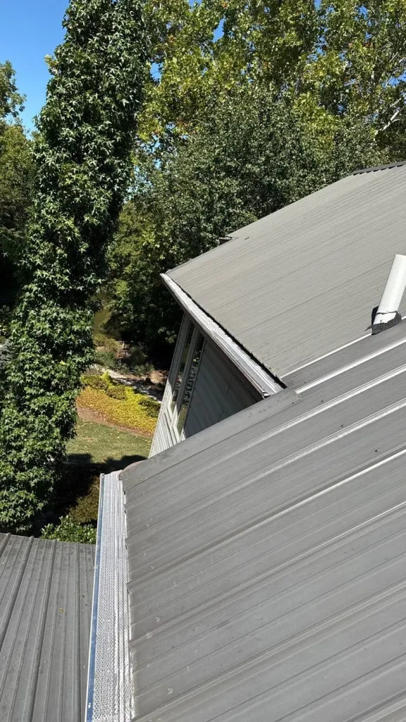 Newly installed gutter guards on a Louisville home with a gray metal roof, designed to keep leaves and debris out.